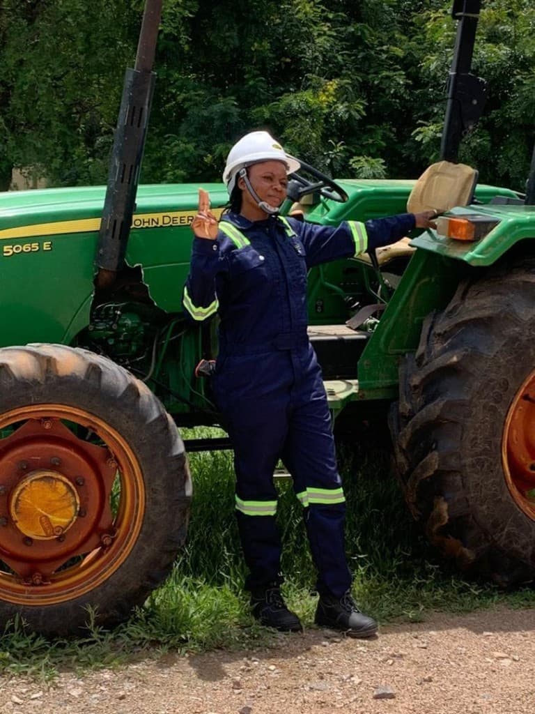 Agricultural professional with John Deere tractor on a commercial farm in Ghana